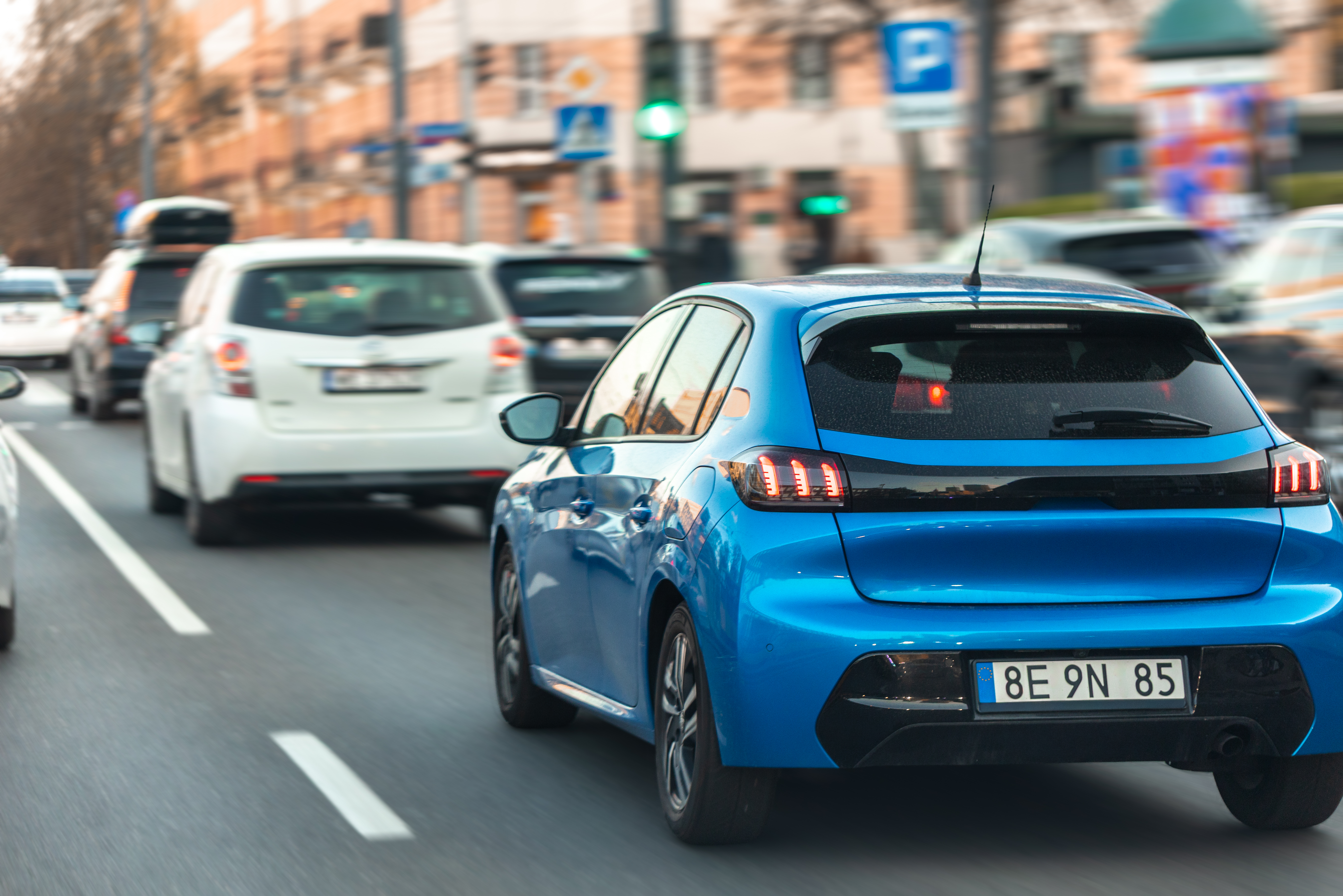 blue-hatchback-driving-city-street-modern-car-heavy-urban-traffic-city-center.jpg