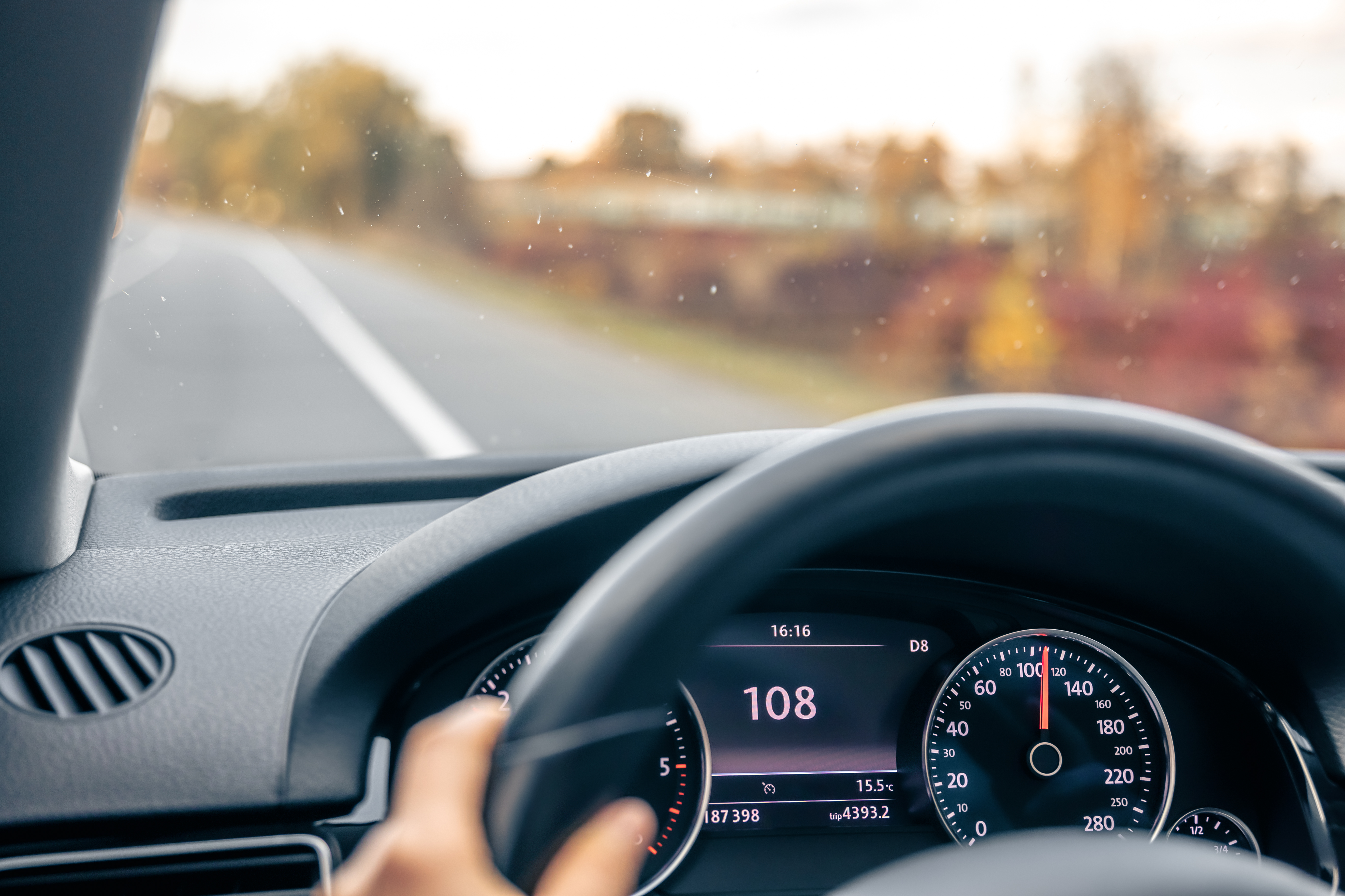steering-wheel-car-close-up-high-speed-driving-road.jpg