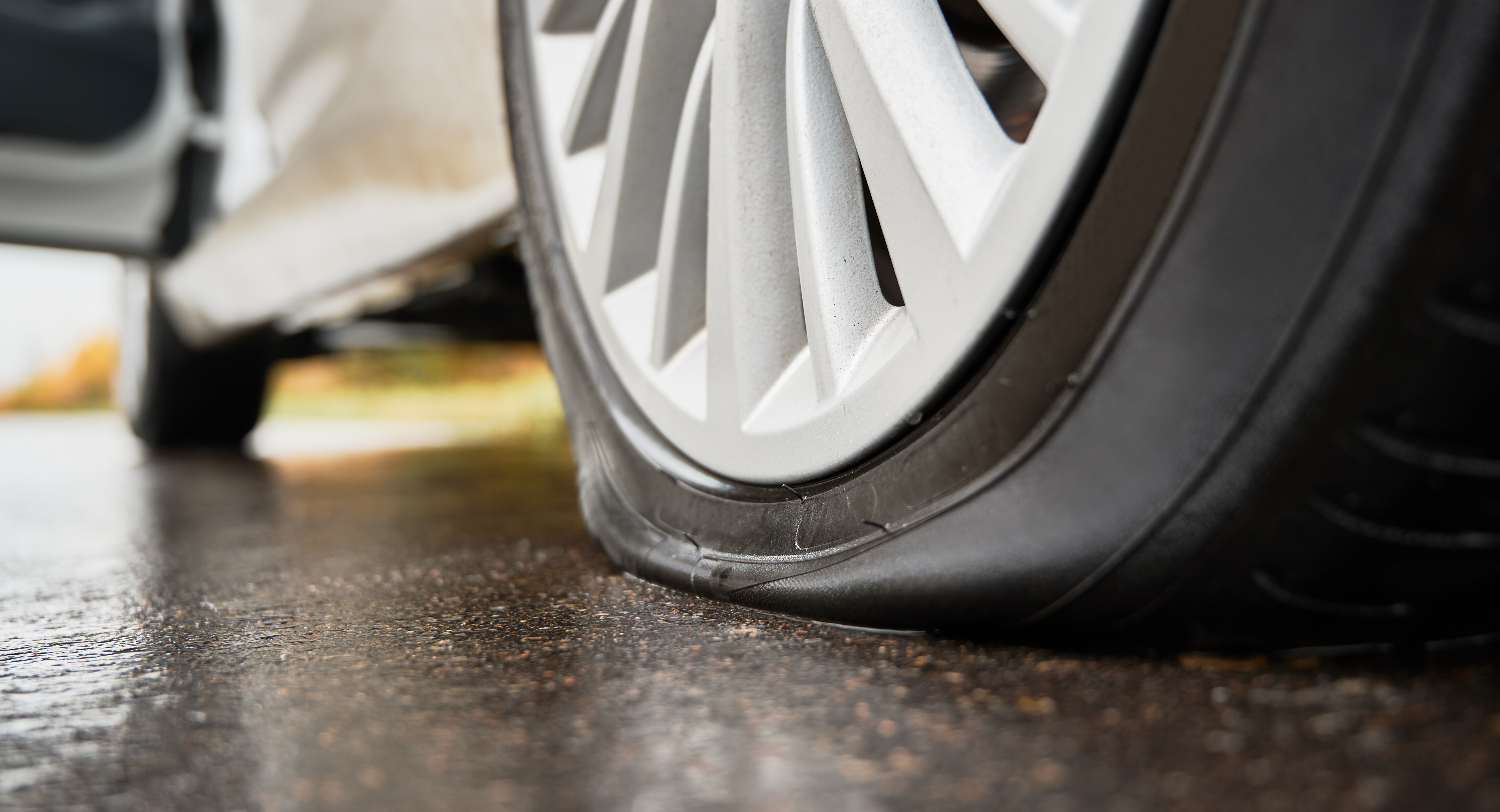 stopped-white-car-with-punctured-tire-roadside.jpg