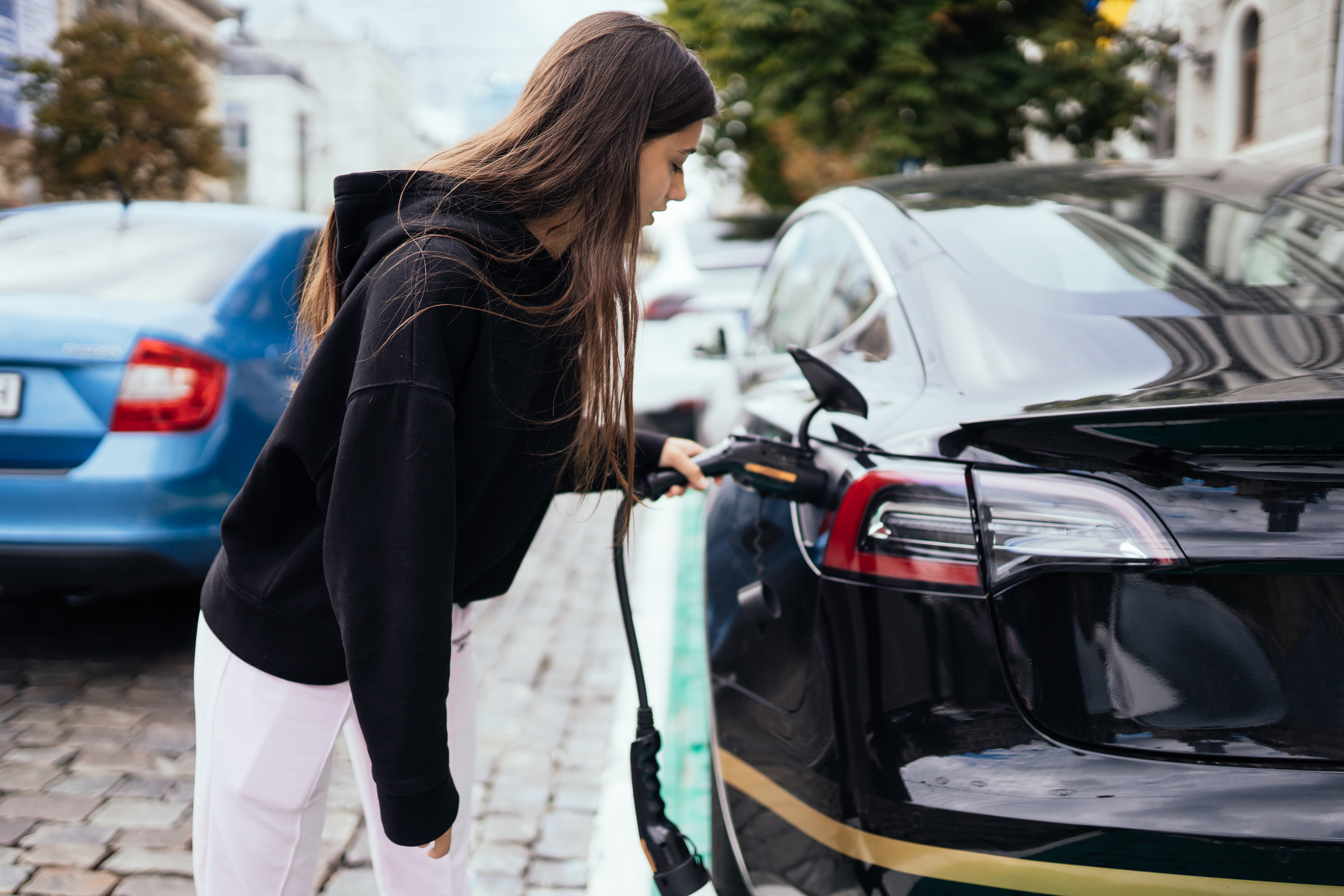 woman-charging-electric-car-charging-station.jpg