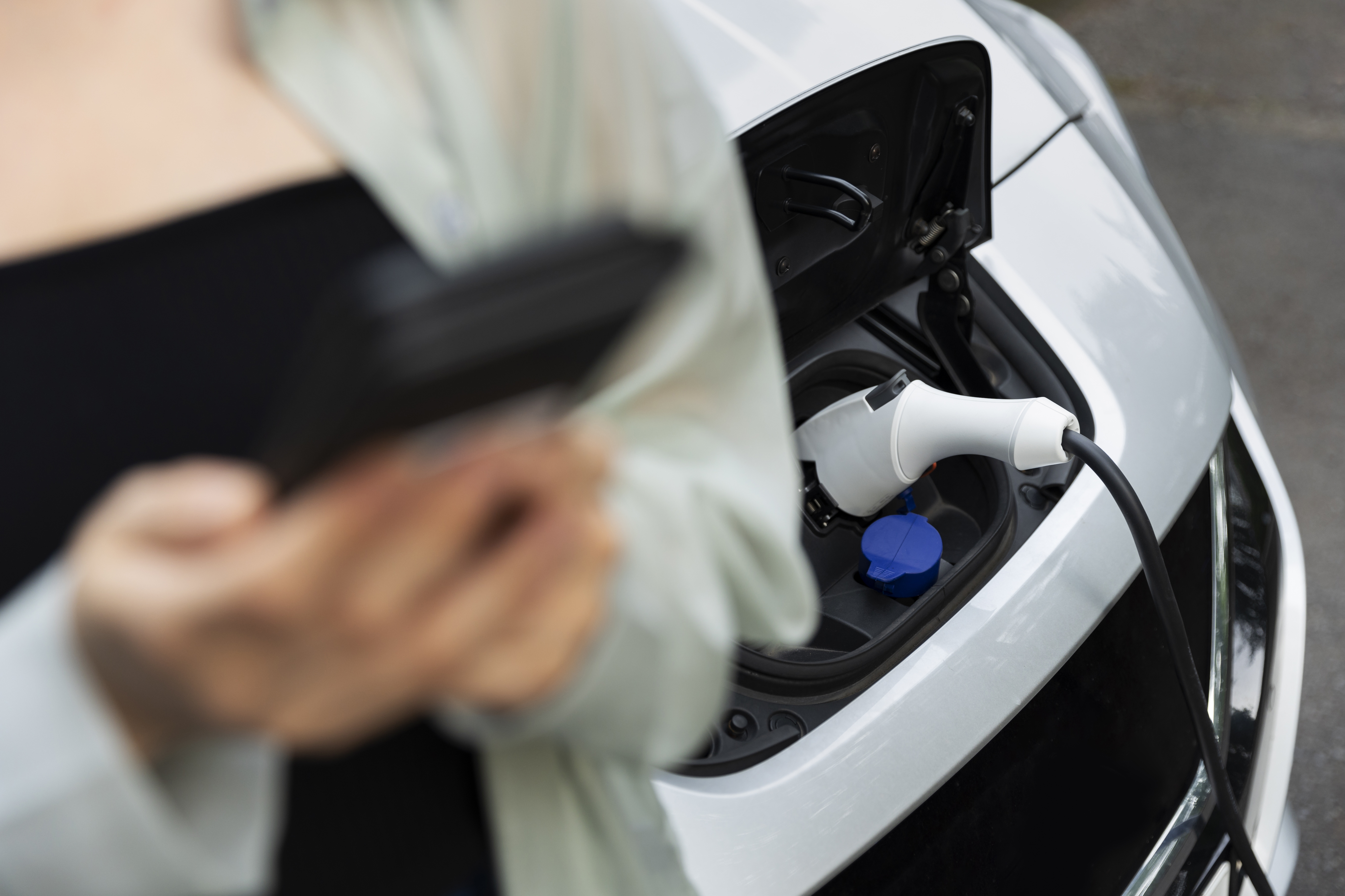 woman-using-her-smartphone-while-electric-car-is-charging.jpg