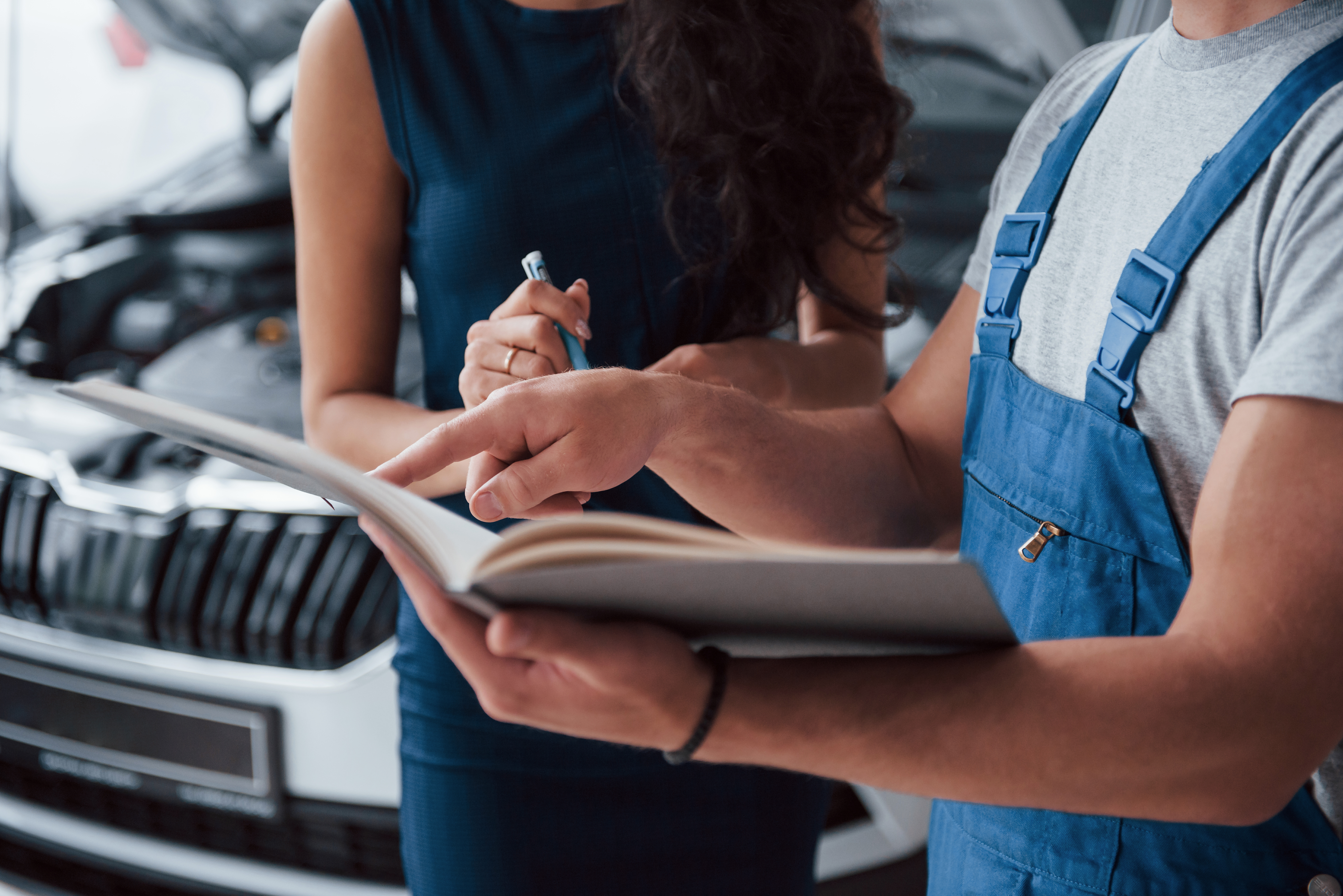 your-signature-please-woman-auto-salon-with-employee-blue-uniform-taking-her-repaired-car-back.jpg
